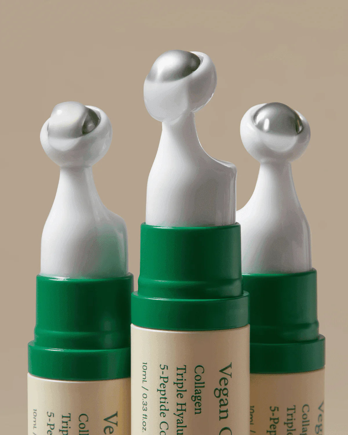 Three Axis-Y Vegan Collagen Eye Serum with green caps on a beige background